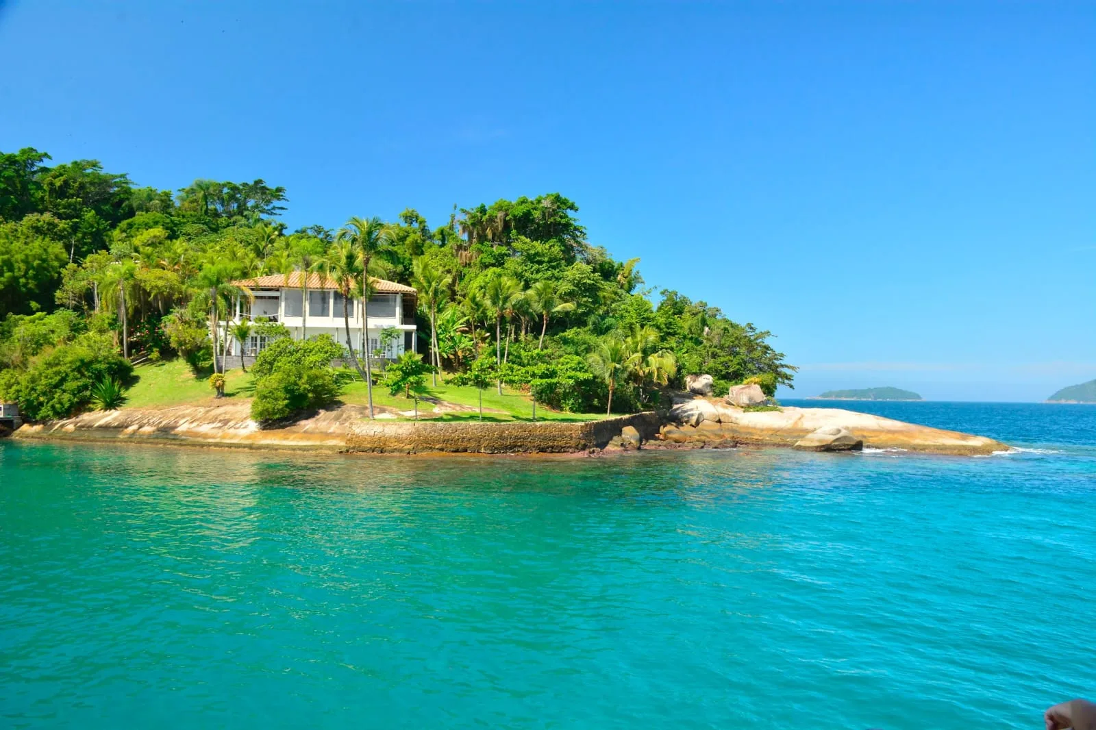Casa entre coqueiros numa ilha da baía de Paraty